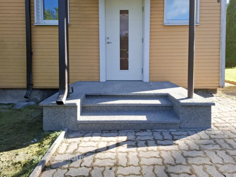 Kollase fassaadiga eramaja trepp on kaetud hallide pesubetoonplaatidega