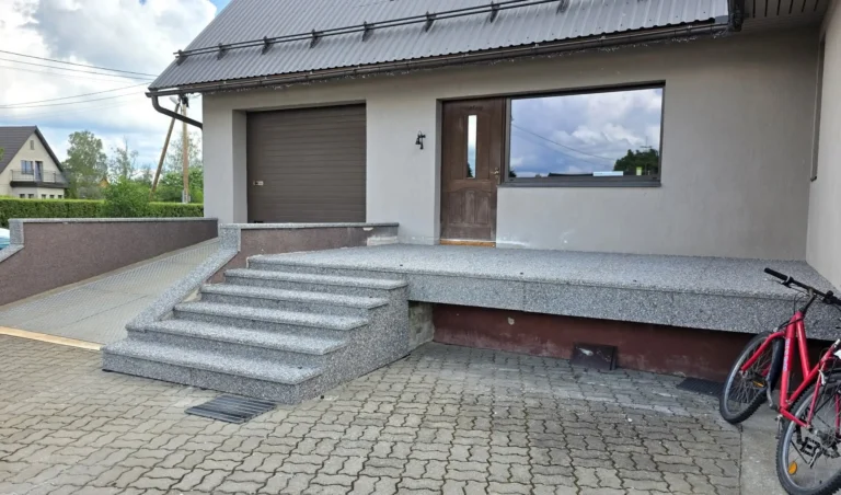 Eramaja välistrepp ja küljemüürid on kaetud hallide pesubetoonplaatidega.