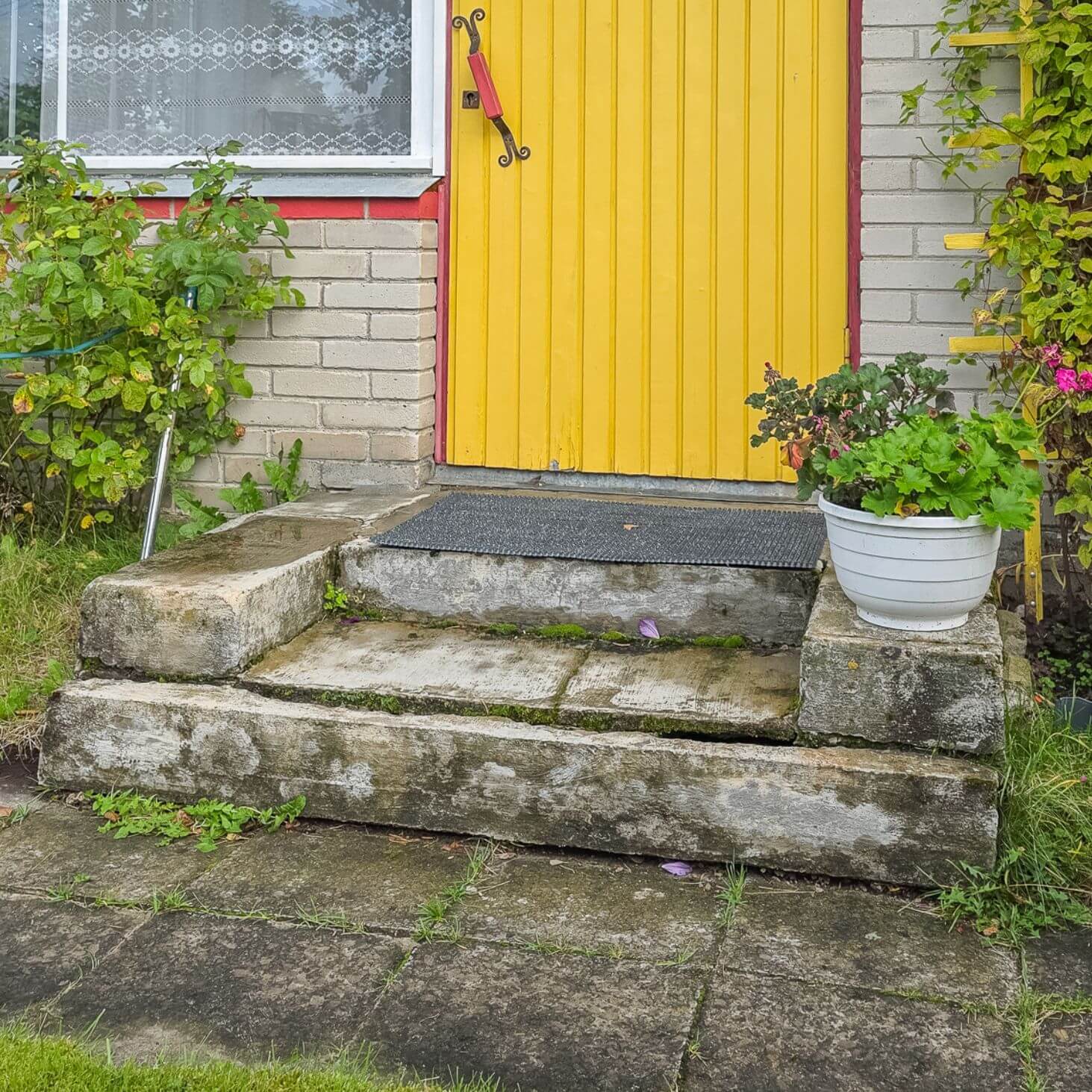 Kollase ukse ees on katkine betoontrepp