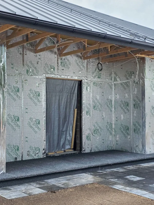 Mustade pesubetoonplaatidega kaetud välistrepp uue maja sissepääsu ees